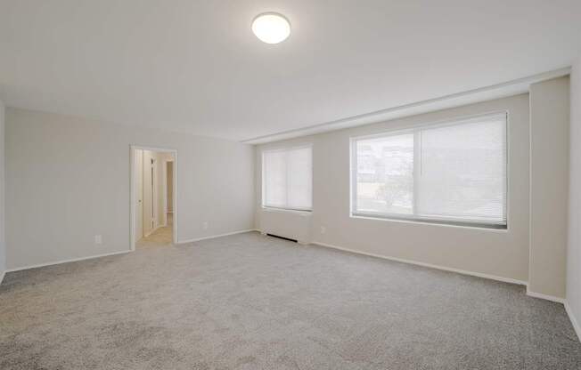 A spacious room with a carpeted floor and a single window.