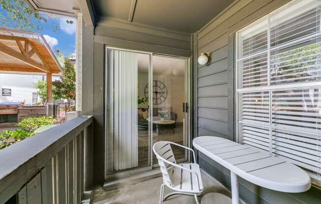 a balcony with a table and chairs and a door to a patio