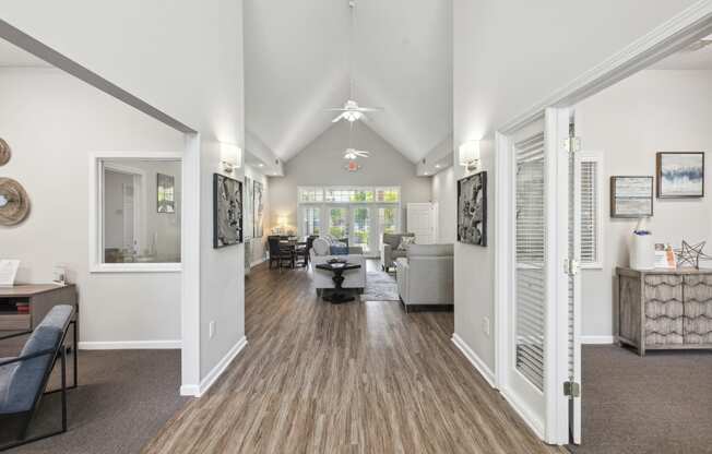 the living room and dining room of a house with white walls and wooden floors