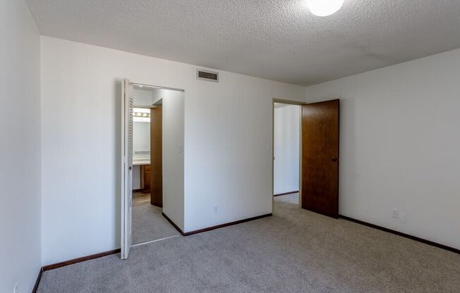 a bedroom with white walls and carpet