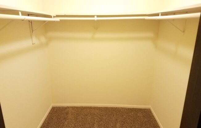 A small, empty room with a carpeted floor and white walls.