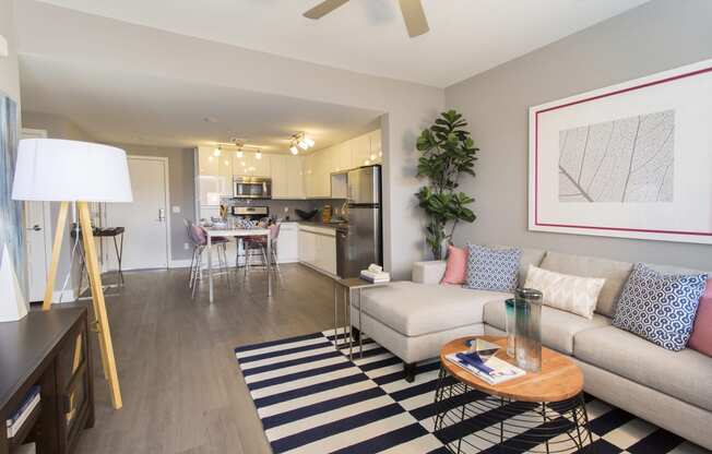 a living room with a couch coffee table and a kitchen in the background