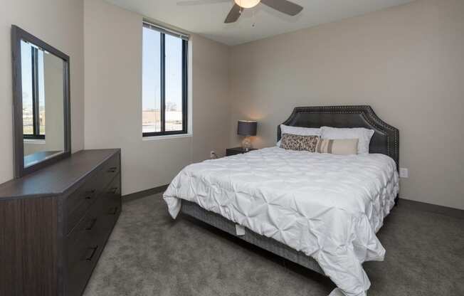 Bright, vacant bedroom with neutral walls and carpet flooring.