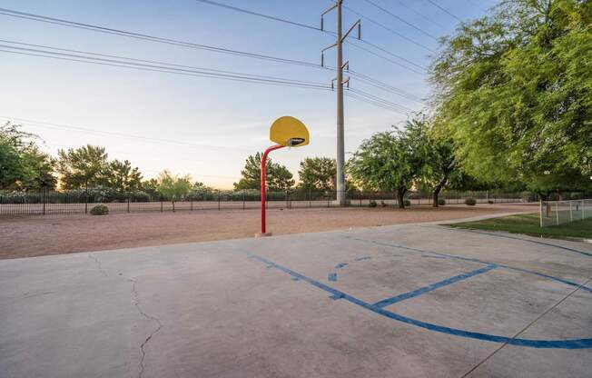 A basketball court with a hoop and blue lines on the ground at Sterling Point Apartment Homes, Phoenix, 85042