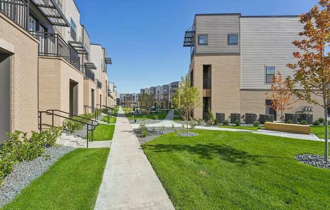 a view of a city street with buildings and grass