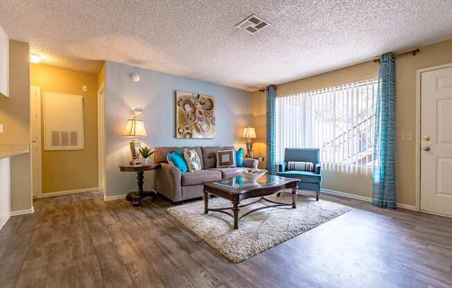 A living room with a couch, a table, and a painting on the wall.