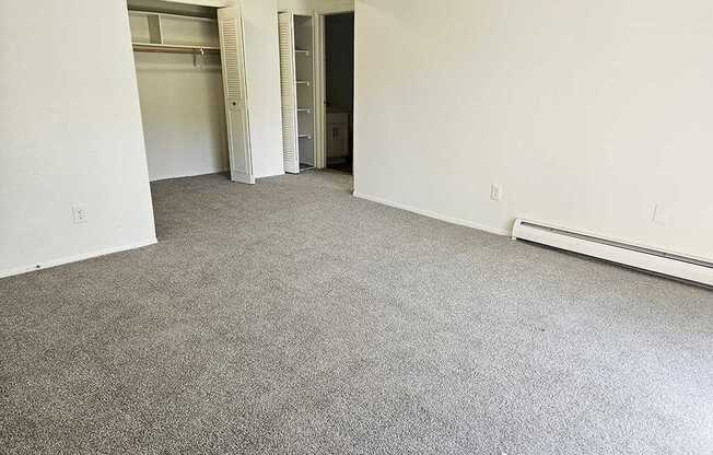A room with a grey carpet and white walls.