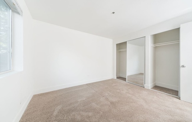 a room with carpet and white walls and sliding glass doors