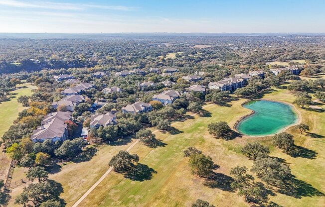 A bird's eye view of a residential area with houses and a lake.
