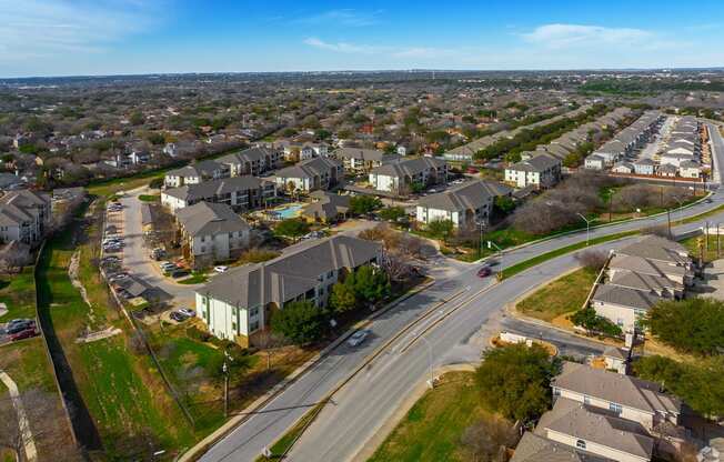 A suburban area with apartment buildings and a road with cars.