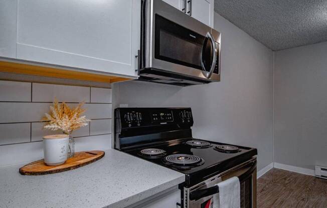 A modern kitchen with a stove, oven, and microwave.