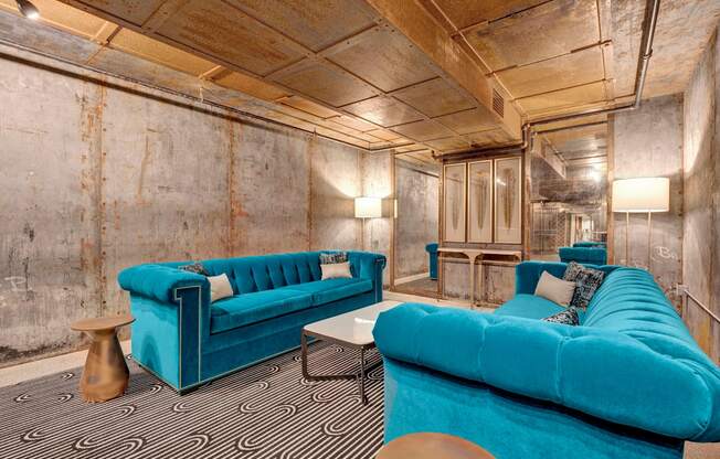 a living room with blue couches and a black and white carpet