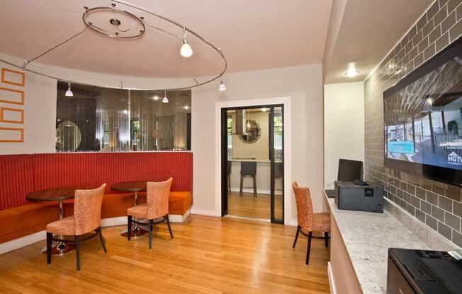 a lobby with a table and chairs and a television