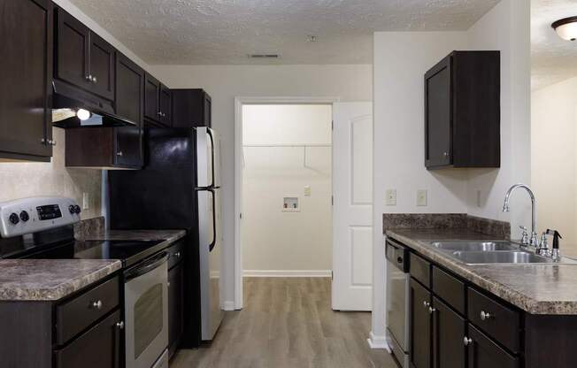 A kitchen with black appliances and cabinets.