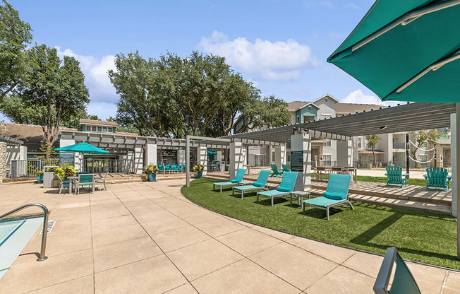 Community Swimming Pool with Pool Furniture at Essence Apartments in Dallas, TX.