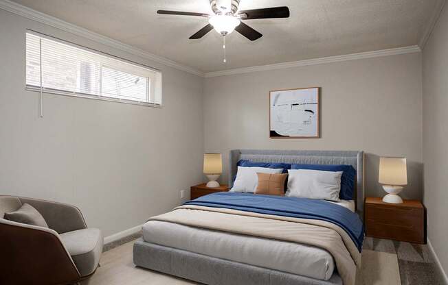 A bedroom with a bed, chair, and ceiling fan.