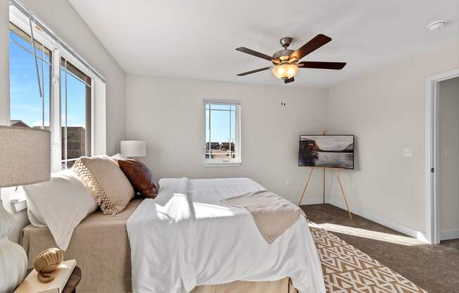 a bedroom with a bed and a ceiling fan at The Residences Apartments at Bear Tree | DeForest, WI, DeForest, 53532
