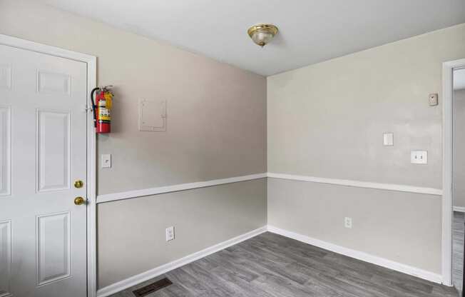 an empty room with a door and a fire hydrant on the wall