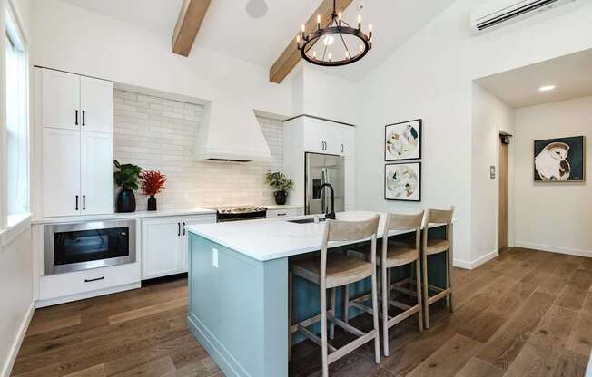 A kitchen with a table and chairs in front of it.