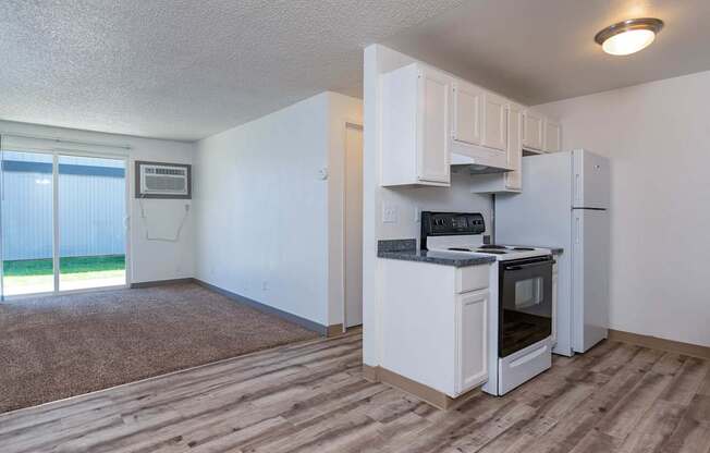 A kitchen with white appliances and a microwave on the counter.