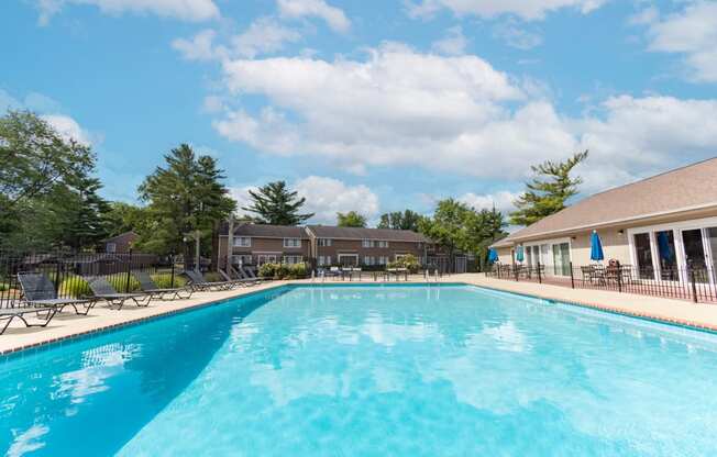 Outdoor swimming pool with seating at Woodbridge Apartments
