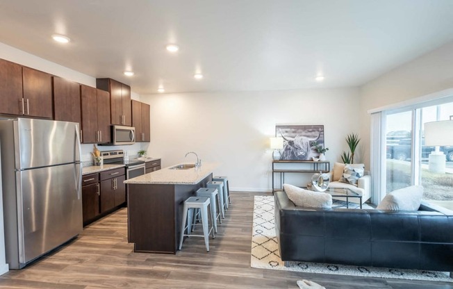 a kitchen and living room with stainless steel appliances and a large window