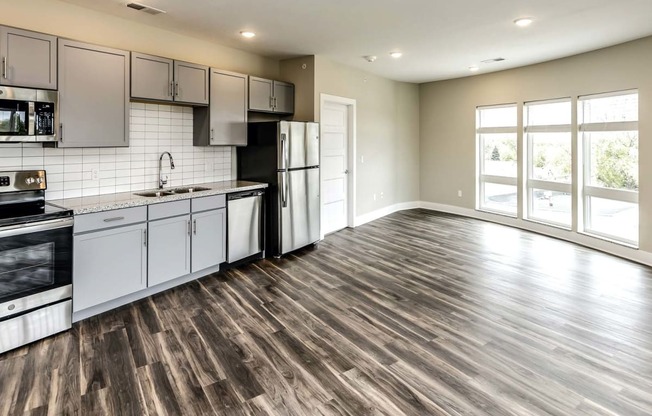 Large kitchens with white or black backsplashes at The Mill Apartments in Benson, NE