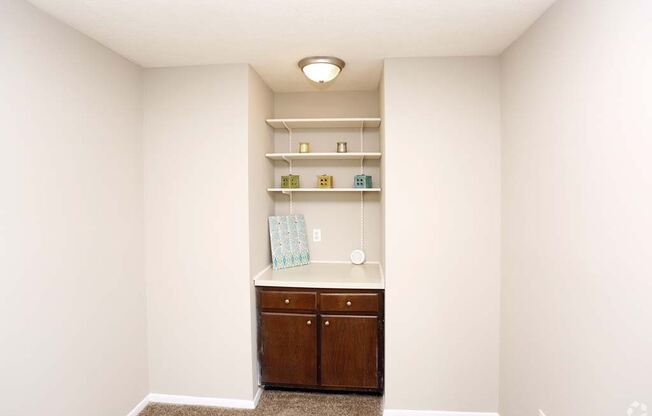 an empty room with a counter and shelves in it