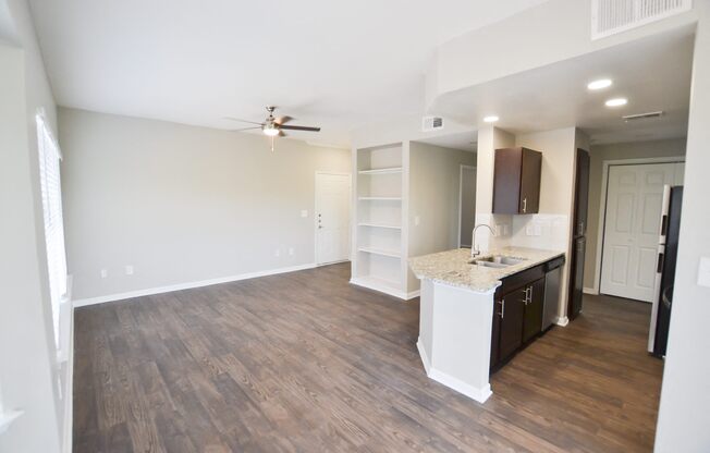 Beautiful upgraded kitchen with stainless steel appliances, granite countertops and walnut brown cabinetry, large open floorplan with built in bookshelves located at The Legends at Eagle Mountain Lak