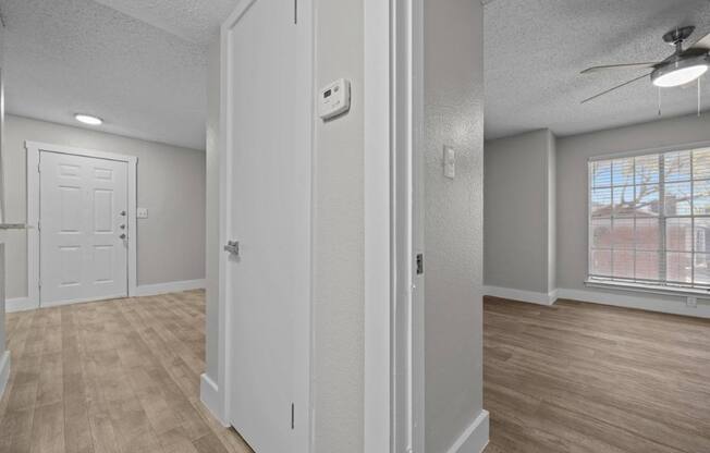 A room with a white door and a window with a view of a building outside.