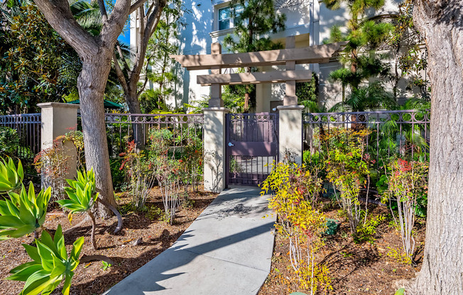 a walkway through a garden with trees and plants