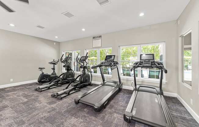 A spacious gym with treadmills and elliptical machines.
