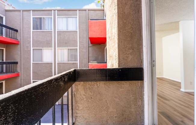A balcony with a black railing and a red object on the wall.
