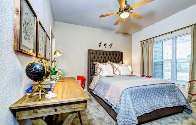 a bedroom with a bed and a ceiling fan at Villa Espada Apartments, Texas