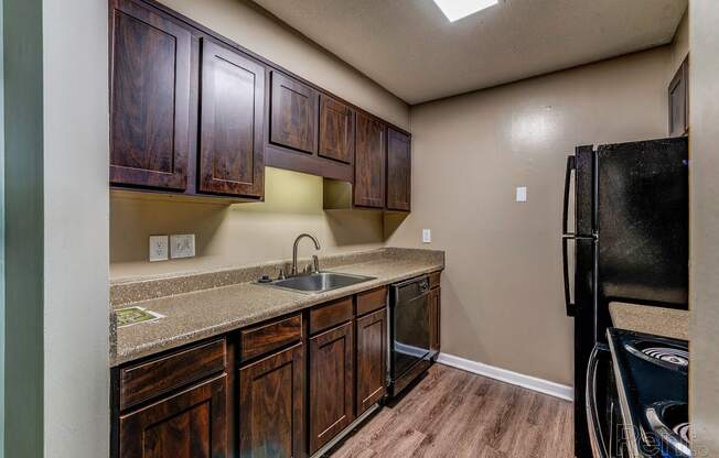 a kitchen with wooden cabinets and a sink and a refrigerator