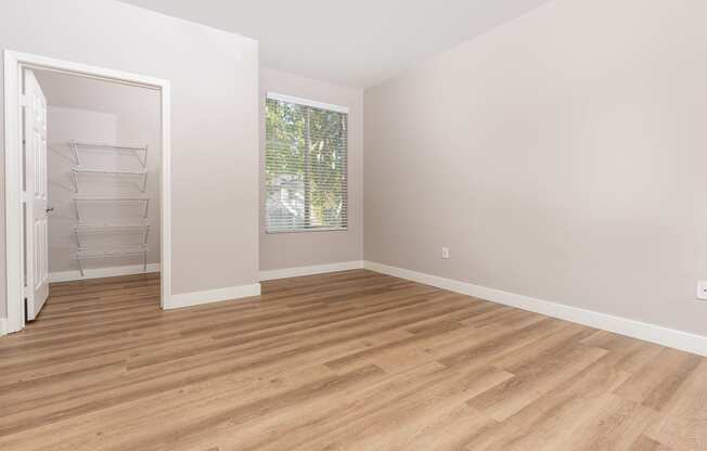 an empty room with wood flooring and a closet