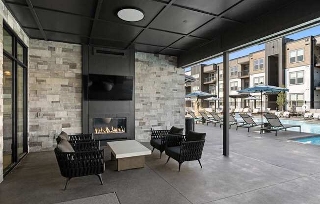 A patio with a fireplace and chairs.
