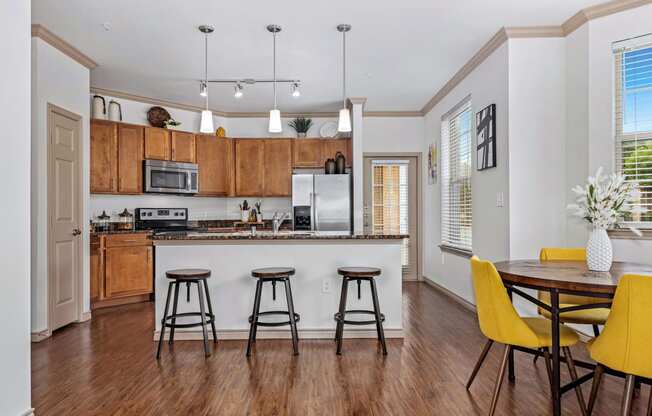 an open kitchen and dining room with a bar and stools