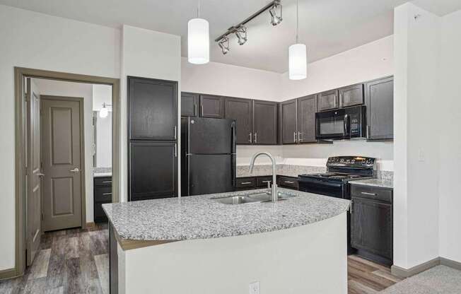 Pet-Friendly Rentals in Bentonville, AR – Parc at Bentonville – A kitchen with black appliances and a granite countertop.