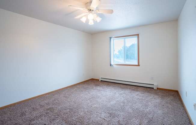 A room with a ceiling fan and a window. Fargo, ND Summit Point Apartments