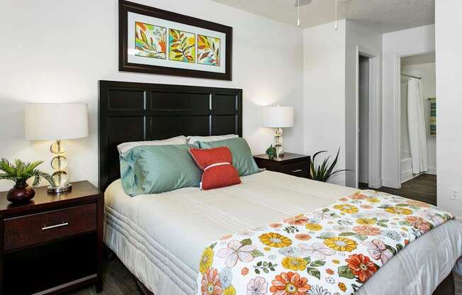 A bedroom with a bed, nightstand, and lamp.