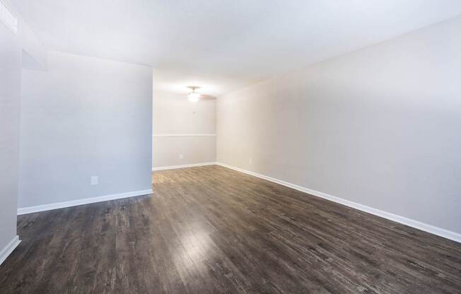 A room with wooden flooring and white walls.