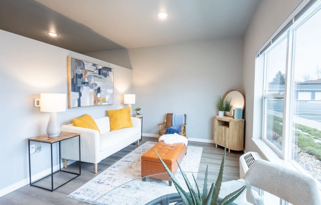a living room with a couch and a coffee table and a large window