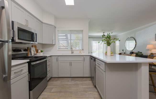 a kitchen with white cabinets and stainless steel appliances