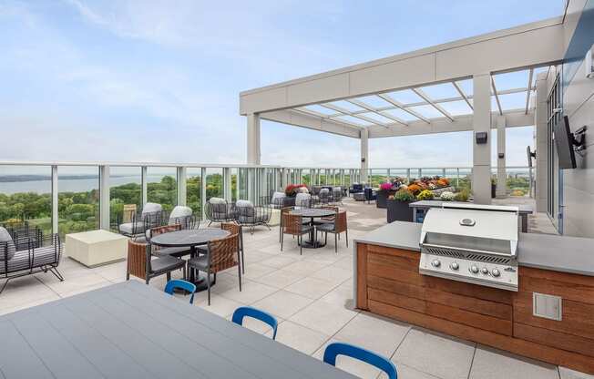 a terrace with tables and chairs and a grill