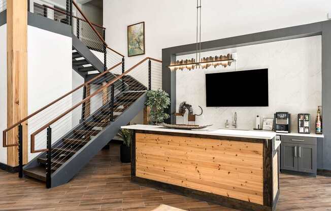 A wooden staircase with a metal railing leads to an upper level.