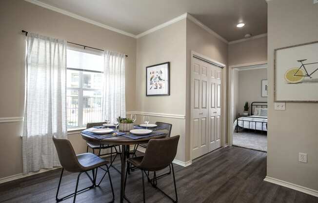 Apartments for Rent in Tyler, TX - Open-Concept Dining Room with Large Window, Wood Flooring, and Access to Bedroom.