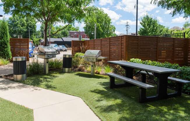 a picnic area with picnic tables and grills in a park at Grand Flats, St. Louis, 63104