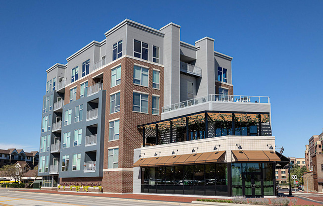 A modern multi-story building with a balcony on the upper floors.