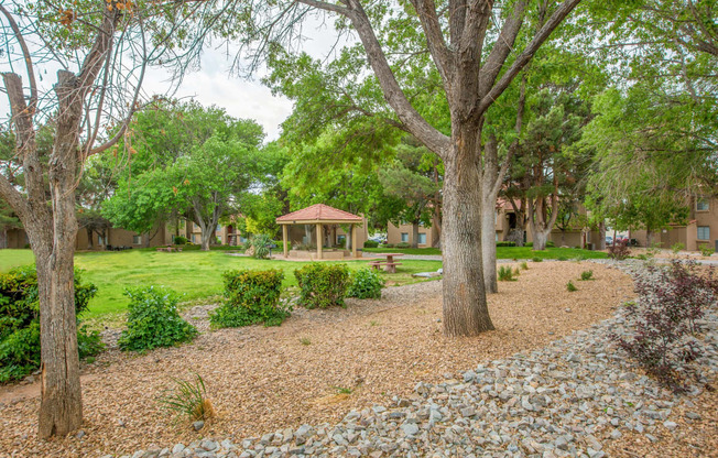 a park with trees and a gazebo in the middle